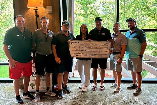 Representatives from Camp Hometown Heroes are presented with their check.