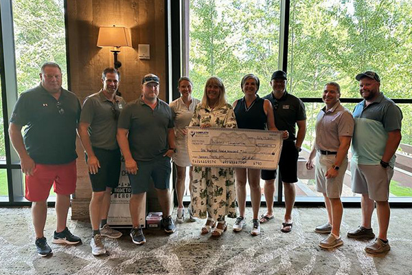 Representatives from the Children's Imaginarium are presented with their check.